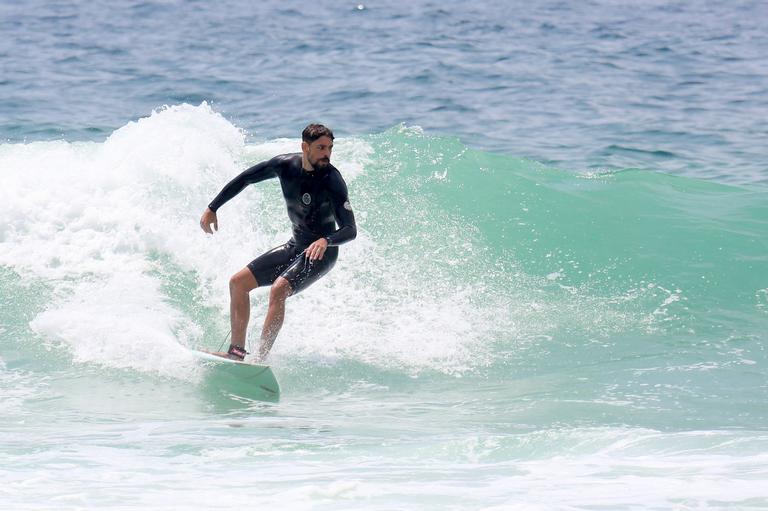 Cauã Reymond e José Loreto surfam em praias cariocas