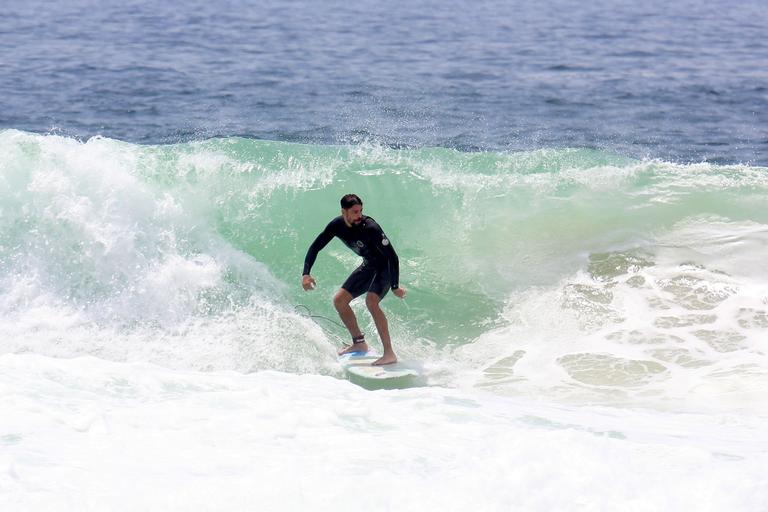 Cauã Reymond e José Loreto surfam em praias cariocas