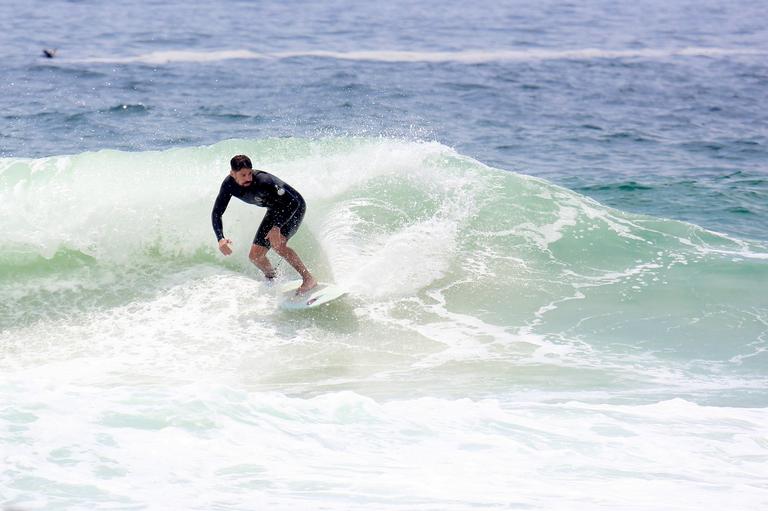 Cauã Reymond e José Loreto surfam em praias cariocas