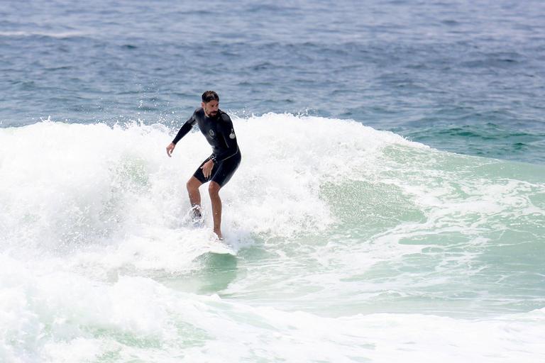 Cauã Reymond e José Loreto surfam em praias cariocas