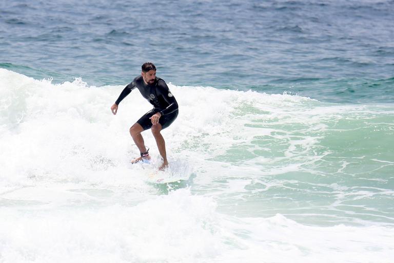 Cauã Reymond e José Loreto surfam em praias cariocas