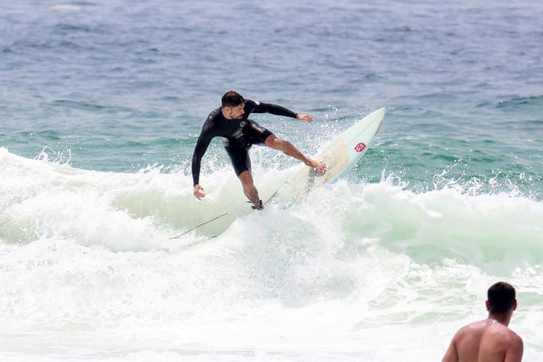 Cauã Reymond e José Loreto surfam em praias cariocas