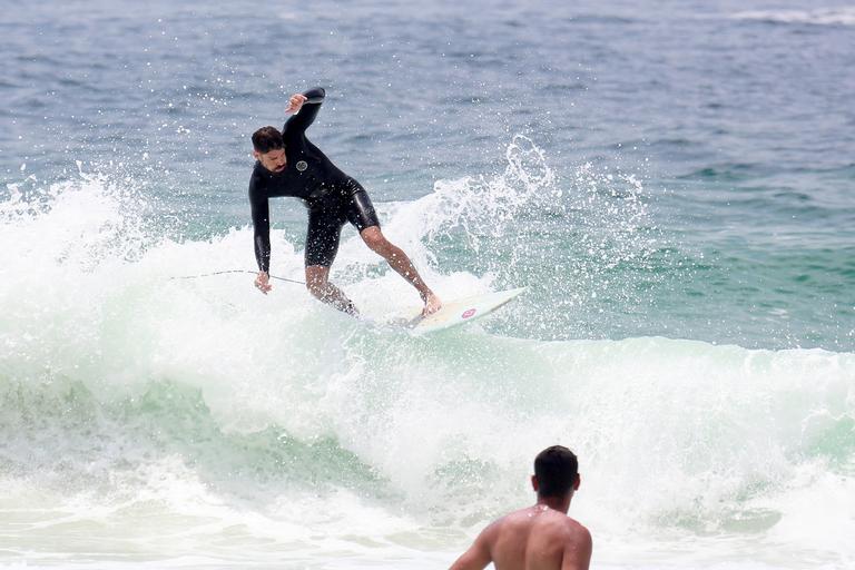 Cauã Reymond e José Loreto surfam em praias cariocas