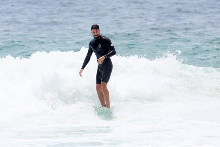 Cauã Reymond e José Loreto surfam em praias cariocas