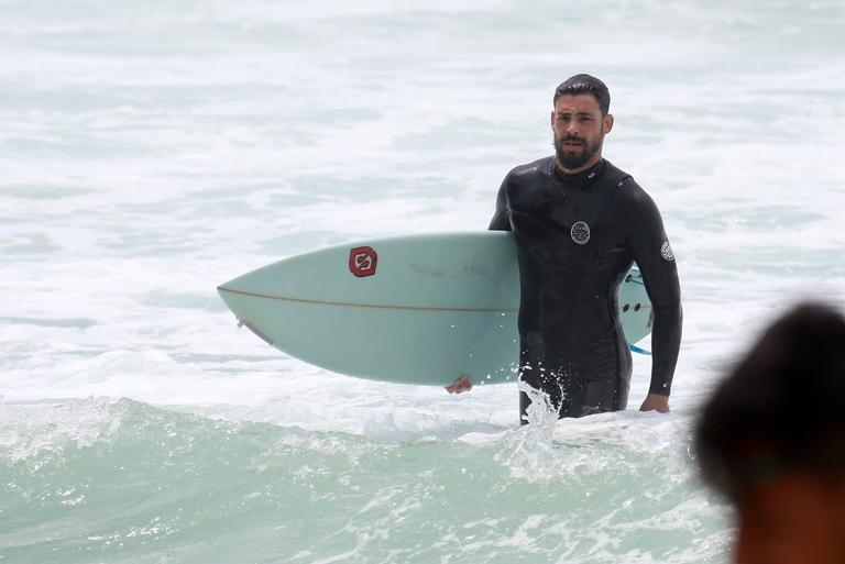 Cauã Reymond e José Loreto surfam em praias cariocas