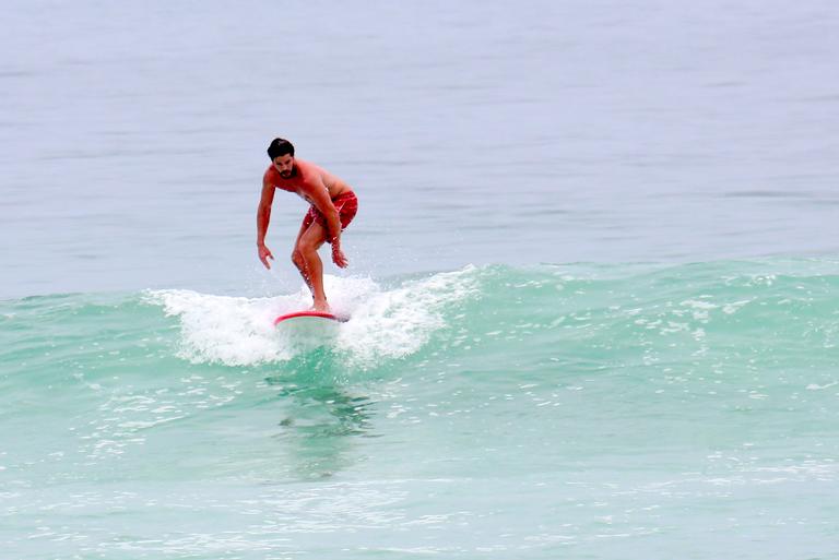 Cauã Reymond e José Loreto surfam em praias cariocas