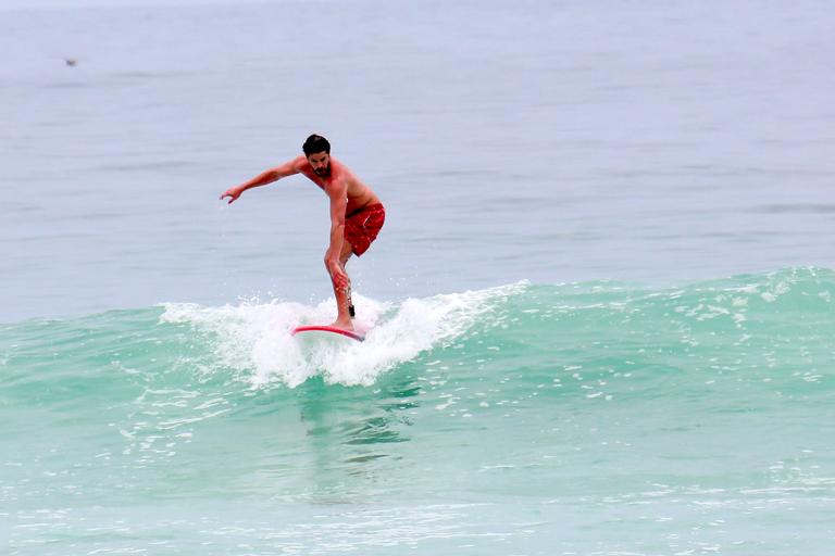 Cauã Reymond e José Loreto surfam em praias cariocas