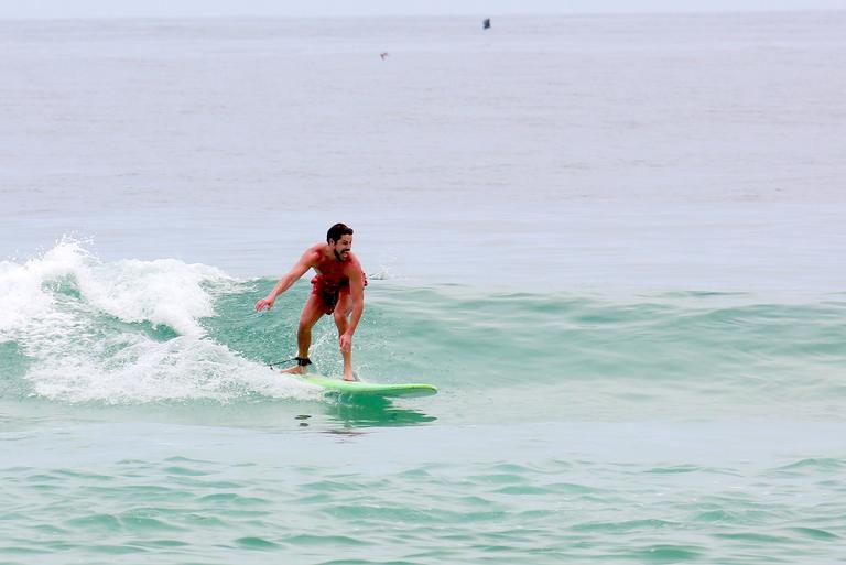 Cauã Reymond e José Loreto surfam em praias cariocas