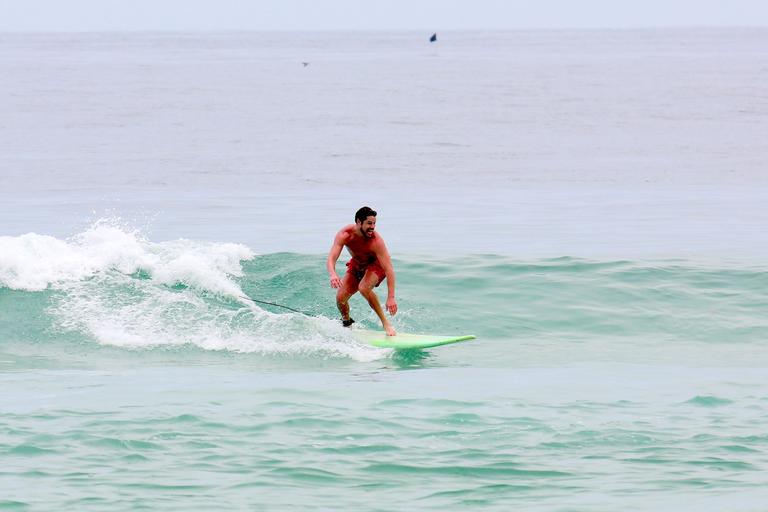 Cauã Reymond e José Loreto surfam em praias cariocas