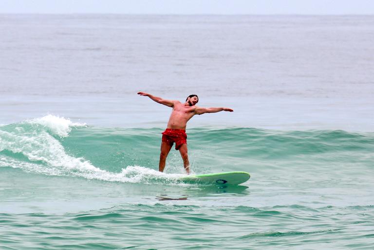 Cauã Reymond e José Loreto surfam em praias cariocas