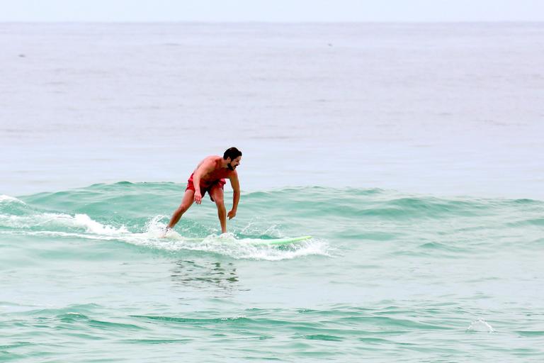 Cauã Reymond e José Loreto surfam em praias cariocas