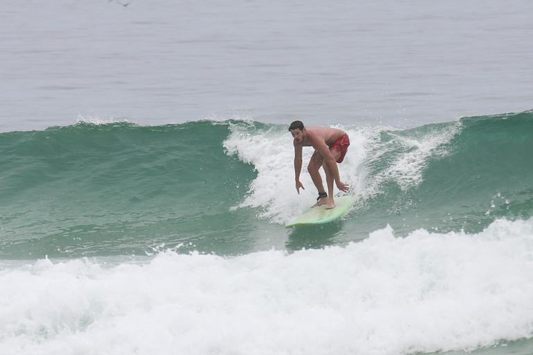 Cauã Reymond e José Loreto surfam em praias cariocas