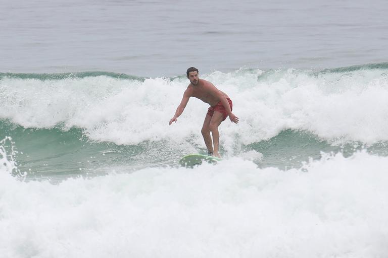 Cauã Reymond e José Loreto surfam em praias cariocas