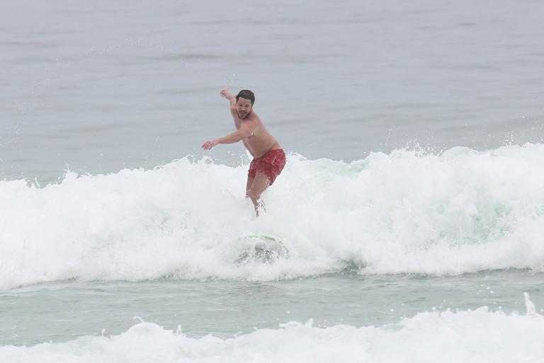 Cauã Reymond e José Loreto surfam em praias cariocas