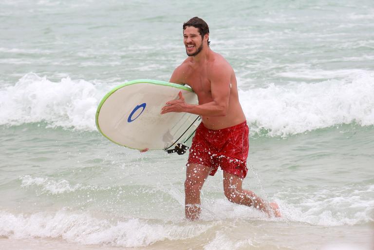 Cauã Reymond e José Loreto surfam em praias cariocas