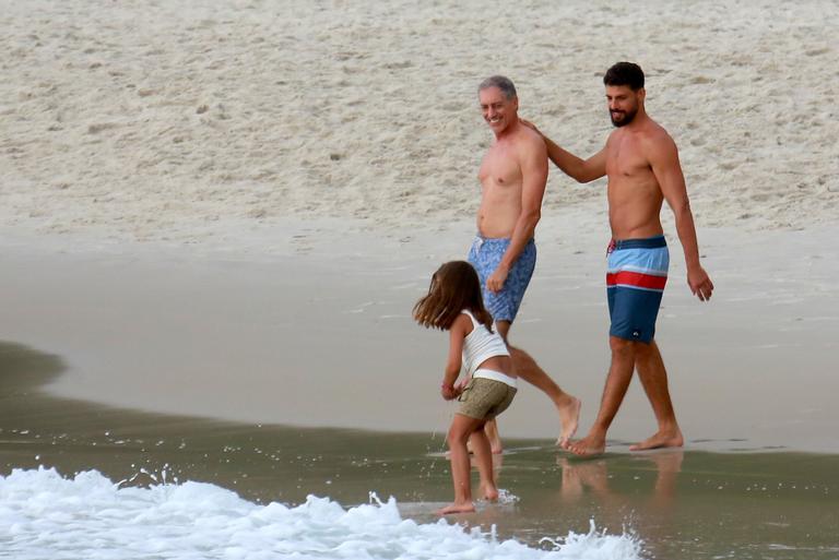 Cauã Reymond curte praia com a filha e o pai