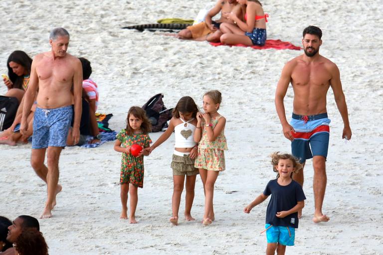 Cauã Reymond curte praia com a filha e o pai