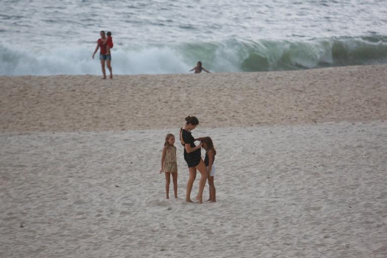 Grazi Massafera brinca com a filha, uma amiguinha e a babá na orla carioca