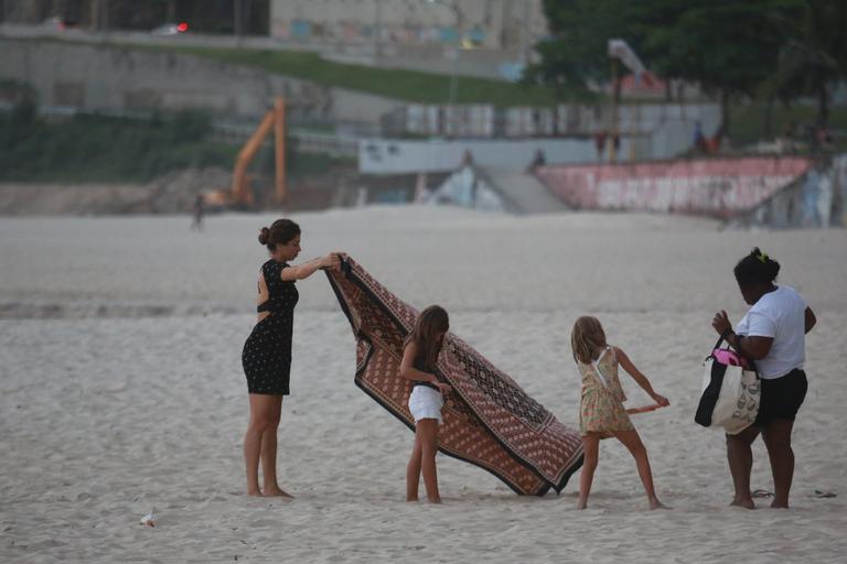 Grazi Massafera brinca com a filha, uma amiguinha e a babá na orla carioca