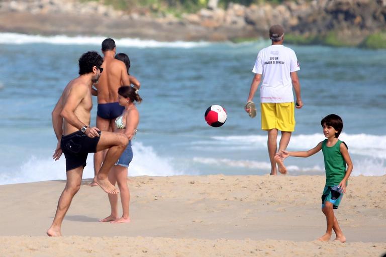 Eriberto Leão joga futebol com o filho na praia