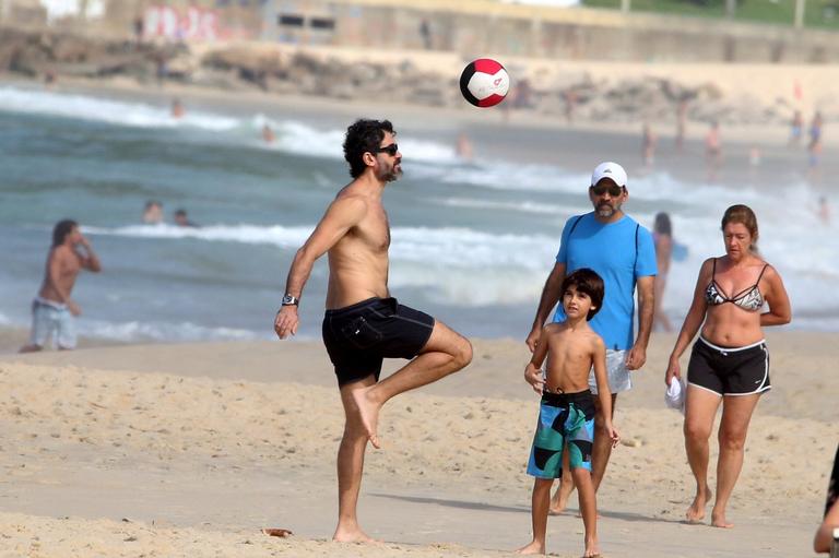 Eriberto Leão joga futebol com o filho na praia