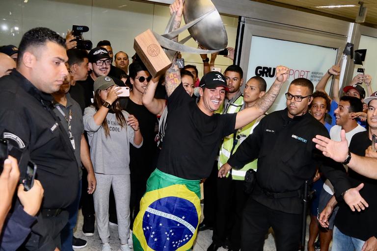 Gabriel Medina chega ao Brasil com troféu e causa tumulto