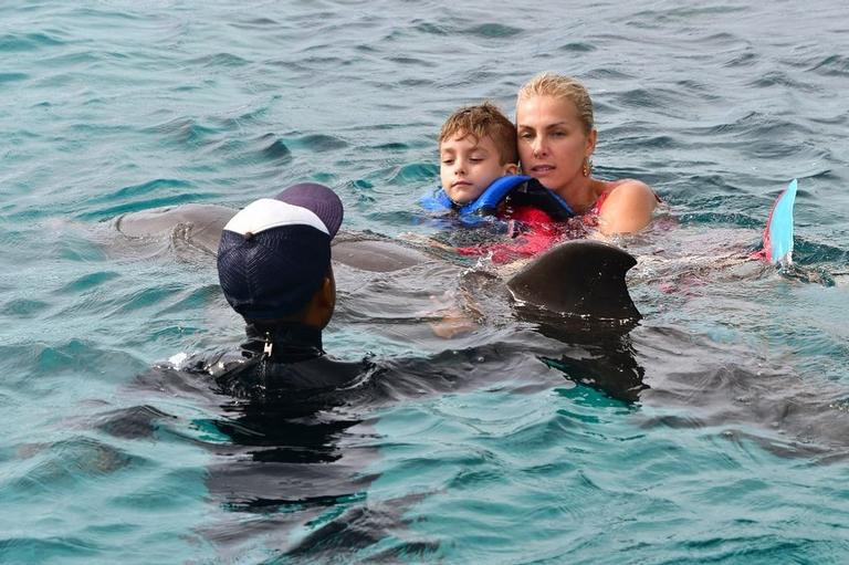 Ana Hickmann com o filho nadando com golfinhos