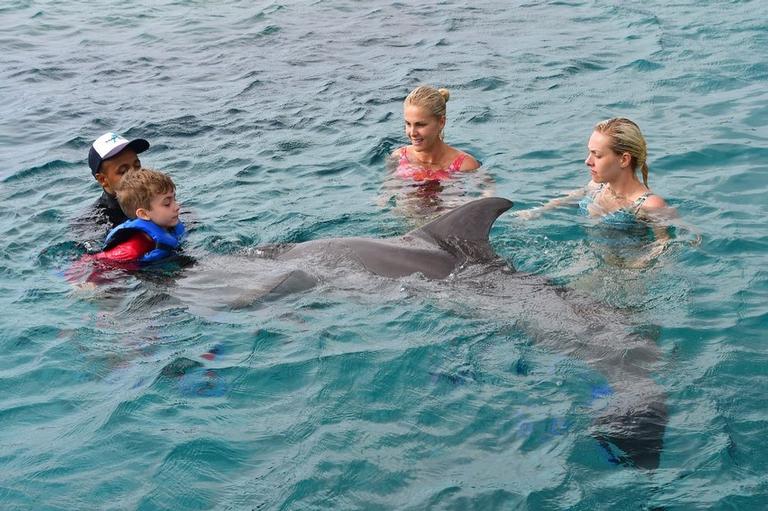 Ana Hickmann com o filho nadando com golfinhos