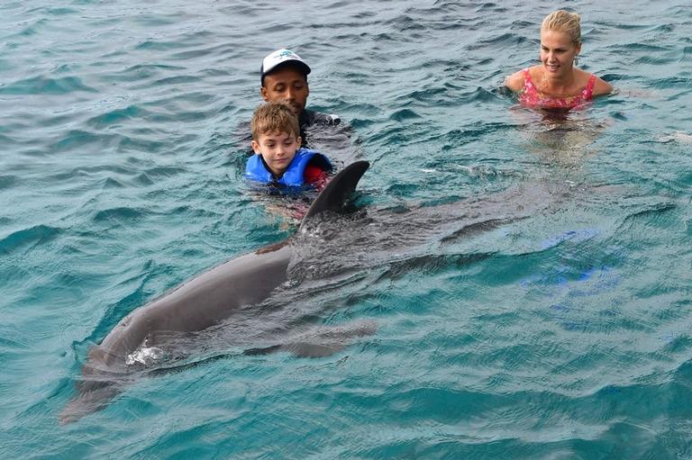 Ana Hickmann com o filho nadando com golfinhos