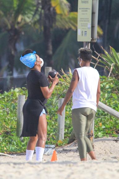 De máscara, Adriana Bombom treina na praia