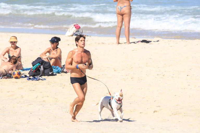 Dado Dolabella é flagrado na praia e exibe barriga sarada