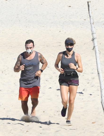 Na praia, Grazi Massafera corre com o personal Chico Salgado