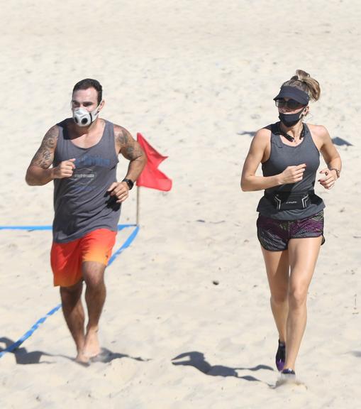 Na praia, Grazi Massafera corre com o personal Chico Salgado