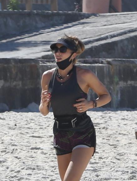 Na praia, Grazi Massafera corre com o personal Chico Salgado