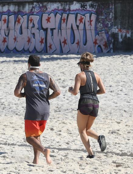 Na praia, Grazi Massafera corre com o personal Chico Salgado