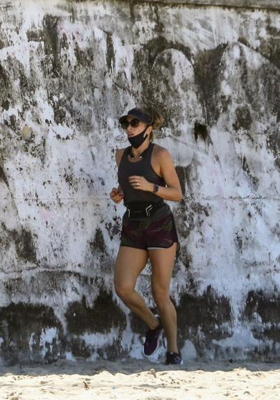 Na praia, Grazi Massafera corre com o personal Chico Salgado