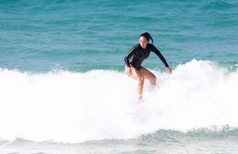 Danni Suzuki é flagrada surfando na praia 