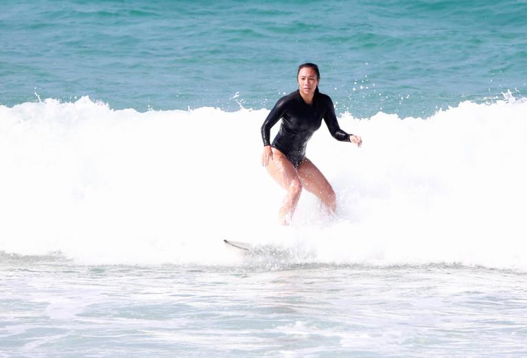 Danni Suzuki é flagrada surfando na praia 