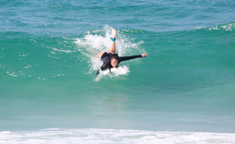 Danni Suzuki é flagrada surfando na praia 