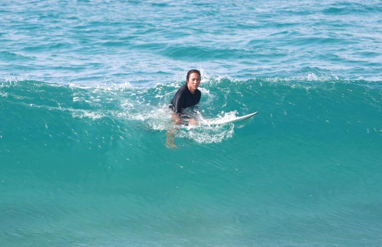 Danni Suzuki é flagrada surfando na praia 