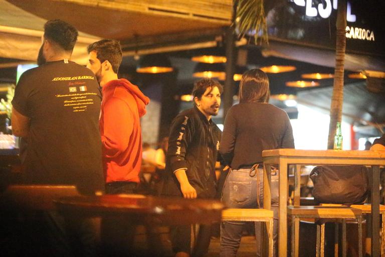 Sem máscara, Douglas Sampaio é flagrado com amigos em bar