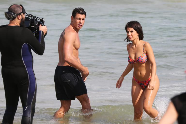 Cauã Reymond e Andrea Horta gravam novela em praia do Rio de Janeiro