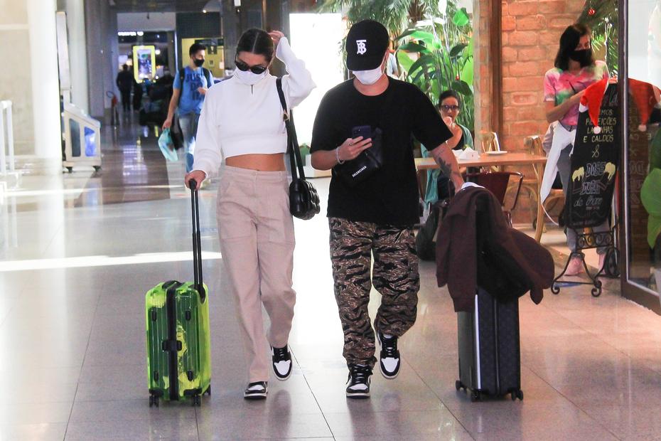 Sasha Menegehel e João Figueiredo de tênis iguais em aeroporto