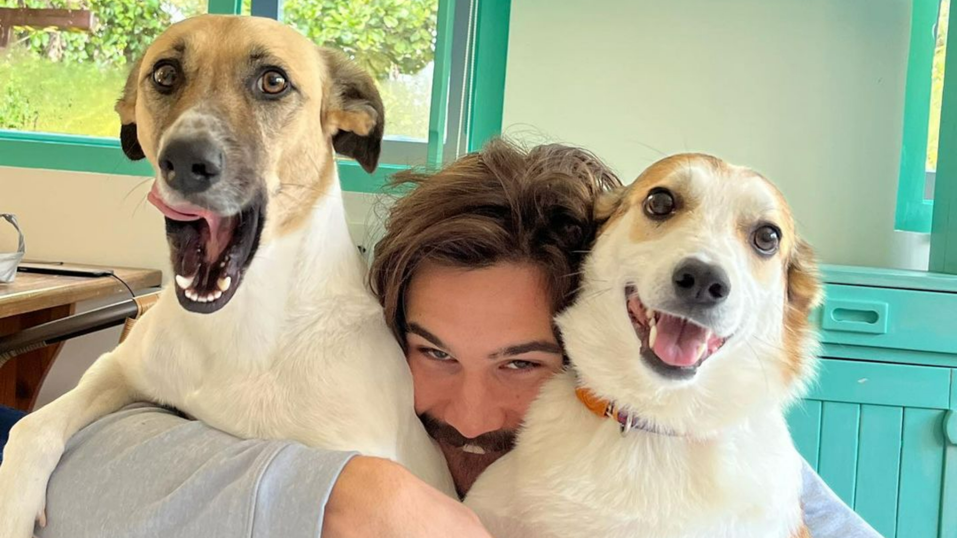 Sem camisa, Nicolas Prattes curte a companhia de seus cachorros