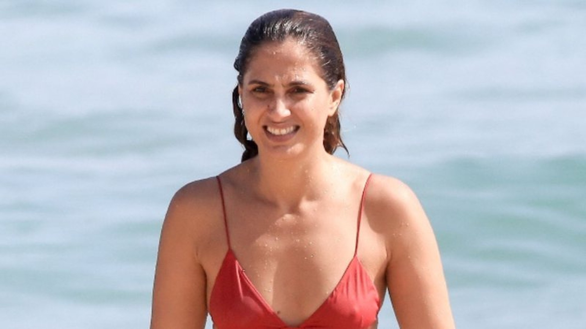 Camila Pitanga se refresca na praia e impressiona com corpão