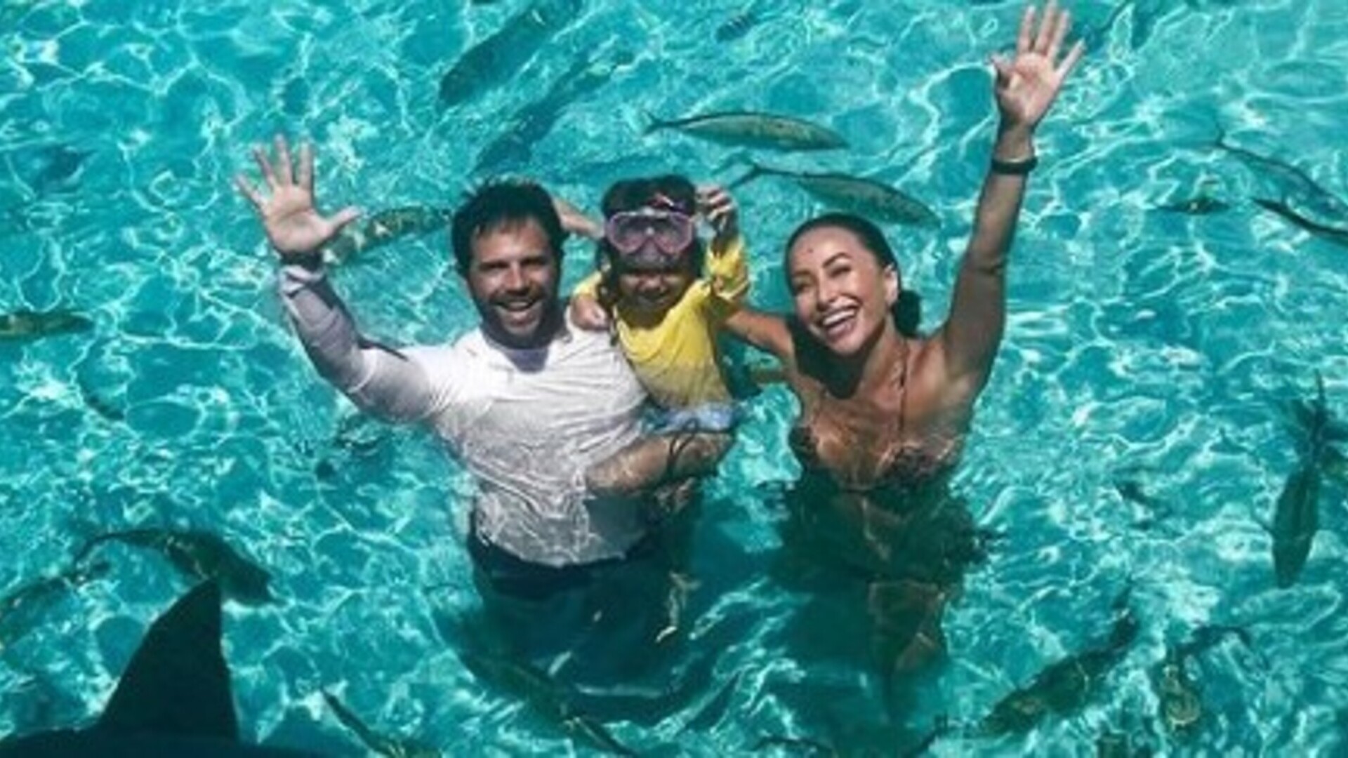 Sabrina Sato e Duda Nagle posam com a filha Zoe ao lado de tubarões