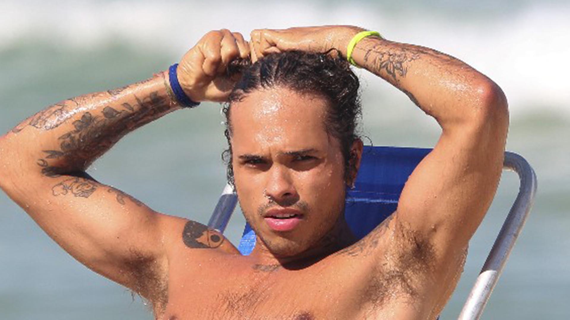 Sem camisa, Vitão relaxa em dia na praia