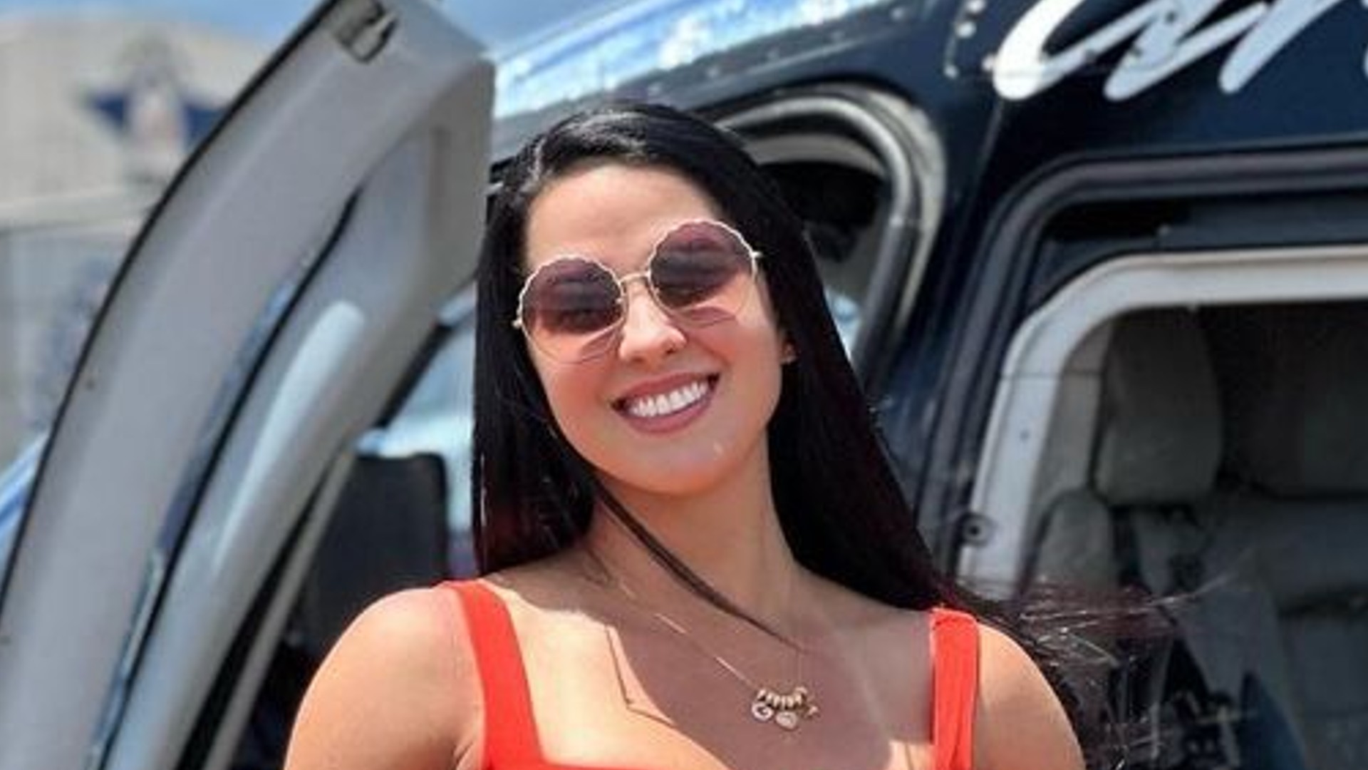 Graciele Lacerda posa de vestido vermelho decotado em helicóptero luxuoso