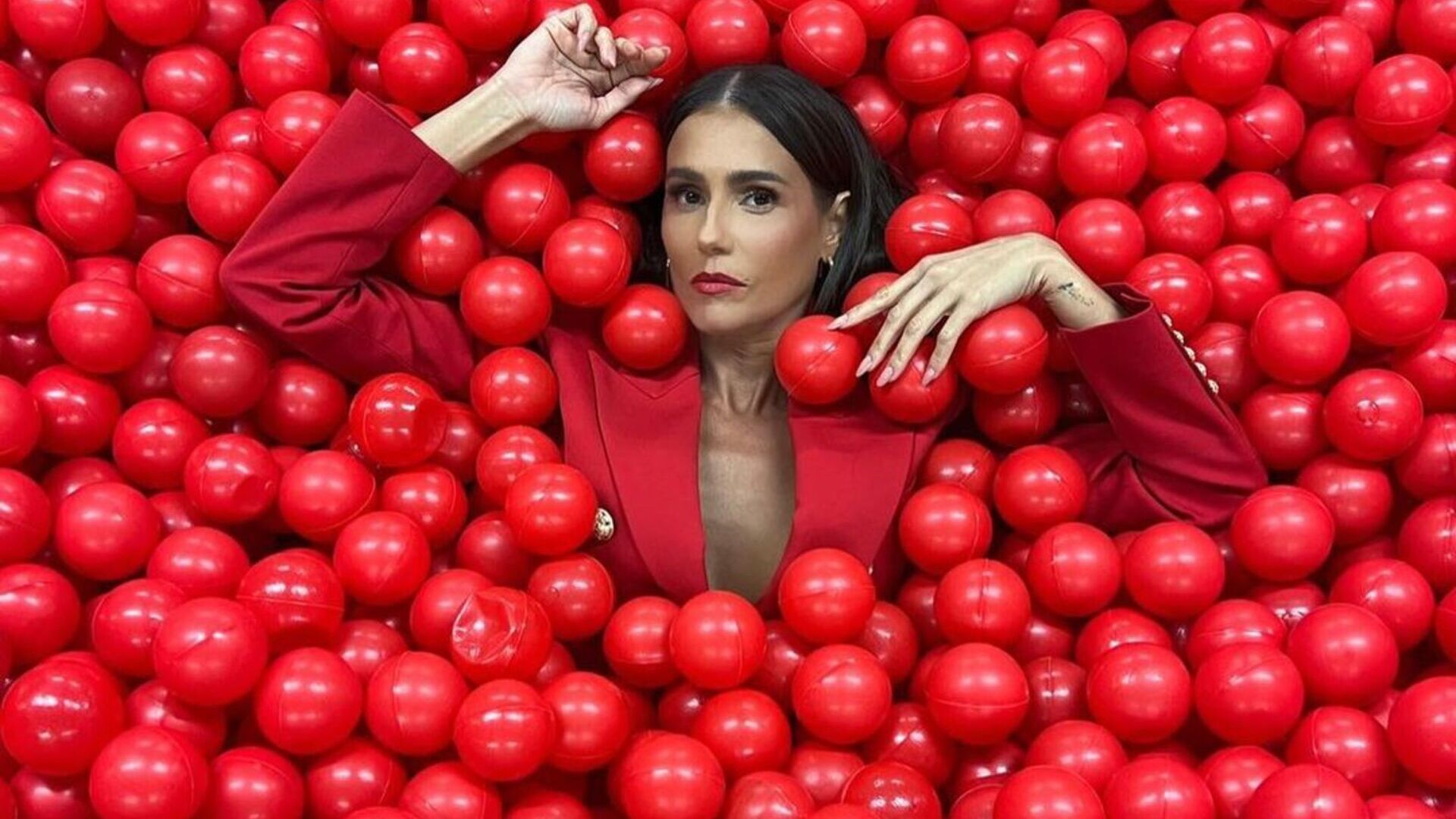 De blazer decotado, Deborah Secco dispensa sutiã em look vermelho e causa: ”Nunca errou”