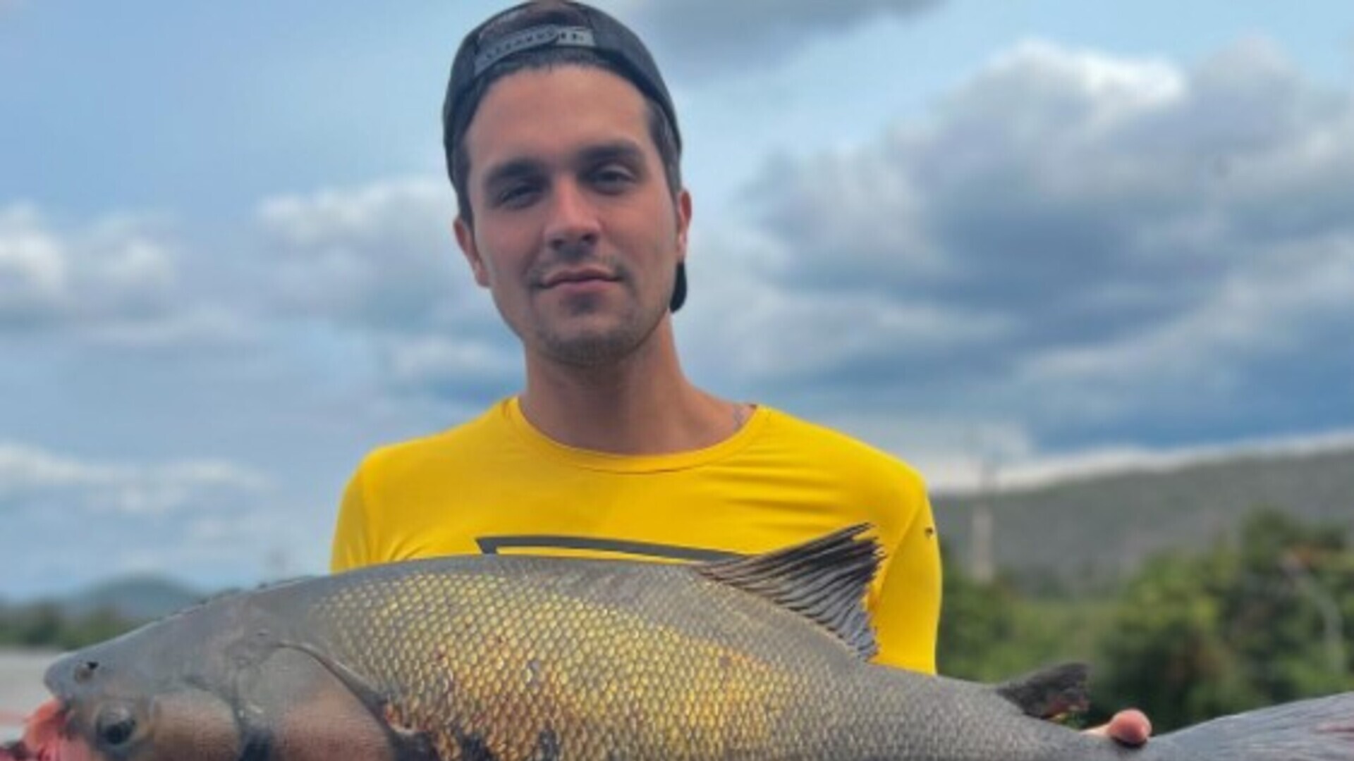 Luan Santana compartilha foto segurando peixe fisgado durante pescaria